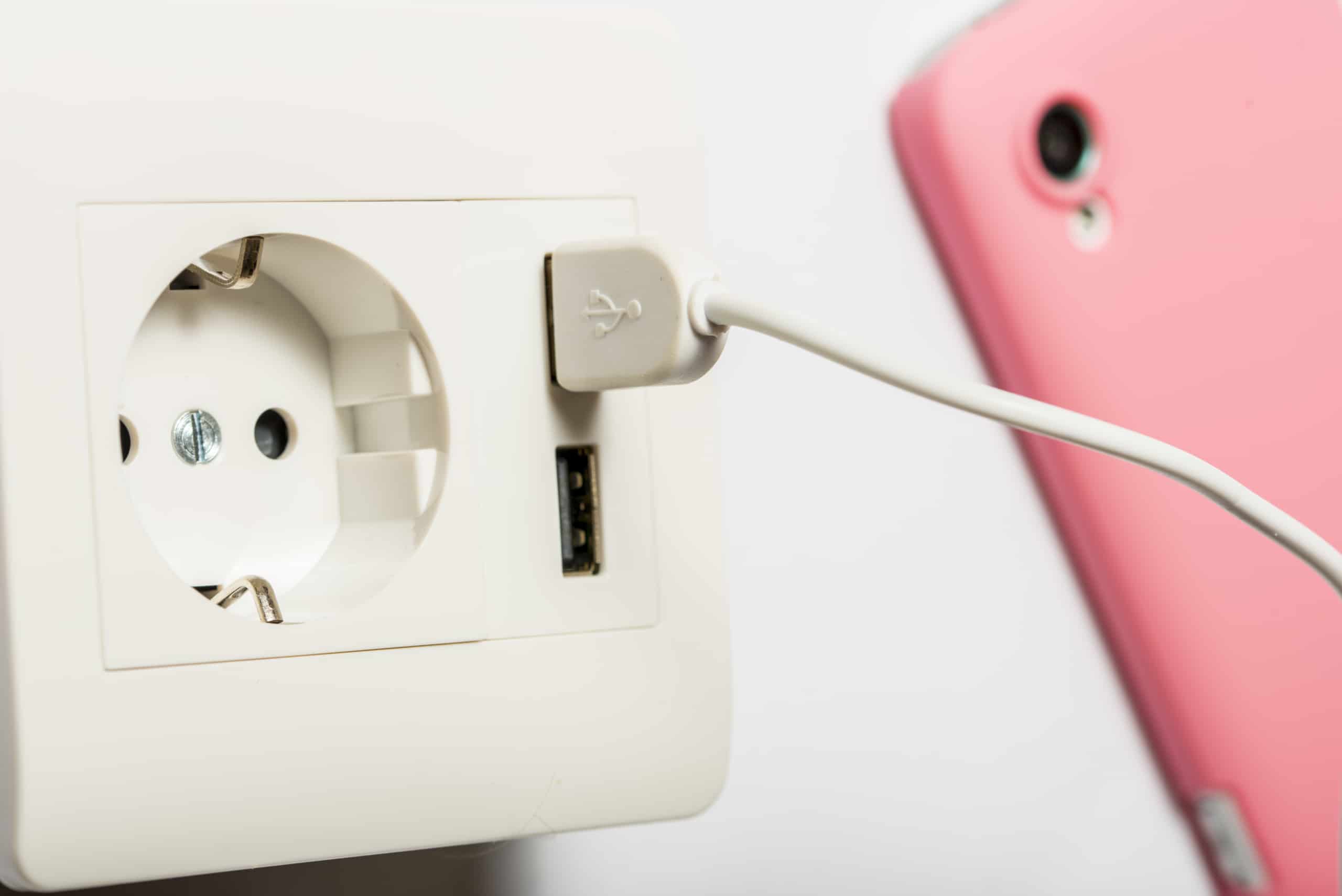Charging. The smartphone charging from the socket, with two usb-charger ports.